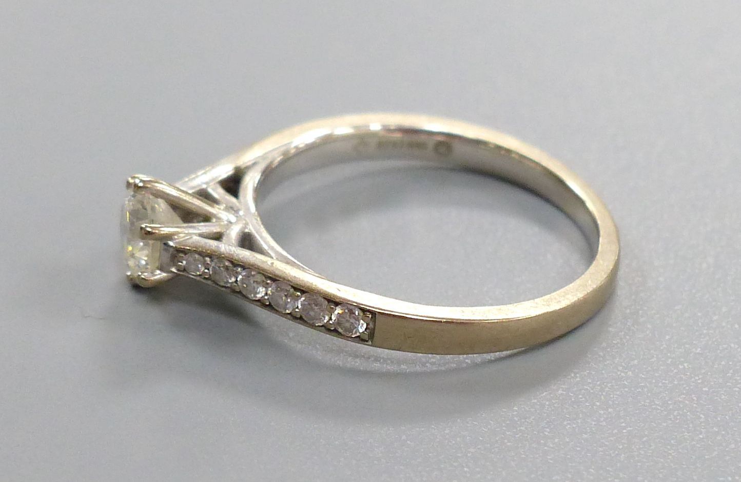 A diamond solitaire ring with diamond-set shoulders, 18ct white gold setting, size L, gross 3.2 grams.